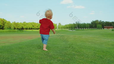 小男孩运行场金发女郎孩子有趣的绿色草地